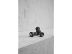 Two black 1kg CRIVIT dumbbells on a concrete surface against a textured wall.
