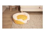 Yellow pet bed with bee print and cream fleece lining on a rug next to a sofa.