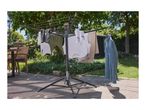 Clothes drying rack with various clothes, including shirts, towels, and a denim jacket, outdoors.
