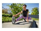 Woman in black and purple activewear stretching outdoors on a sunny day.