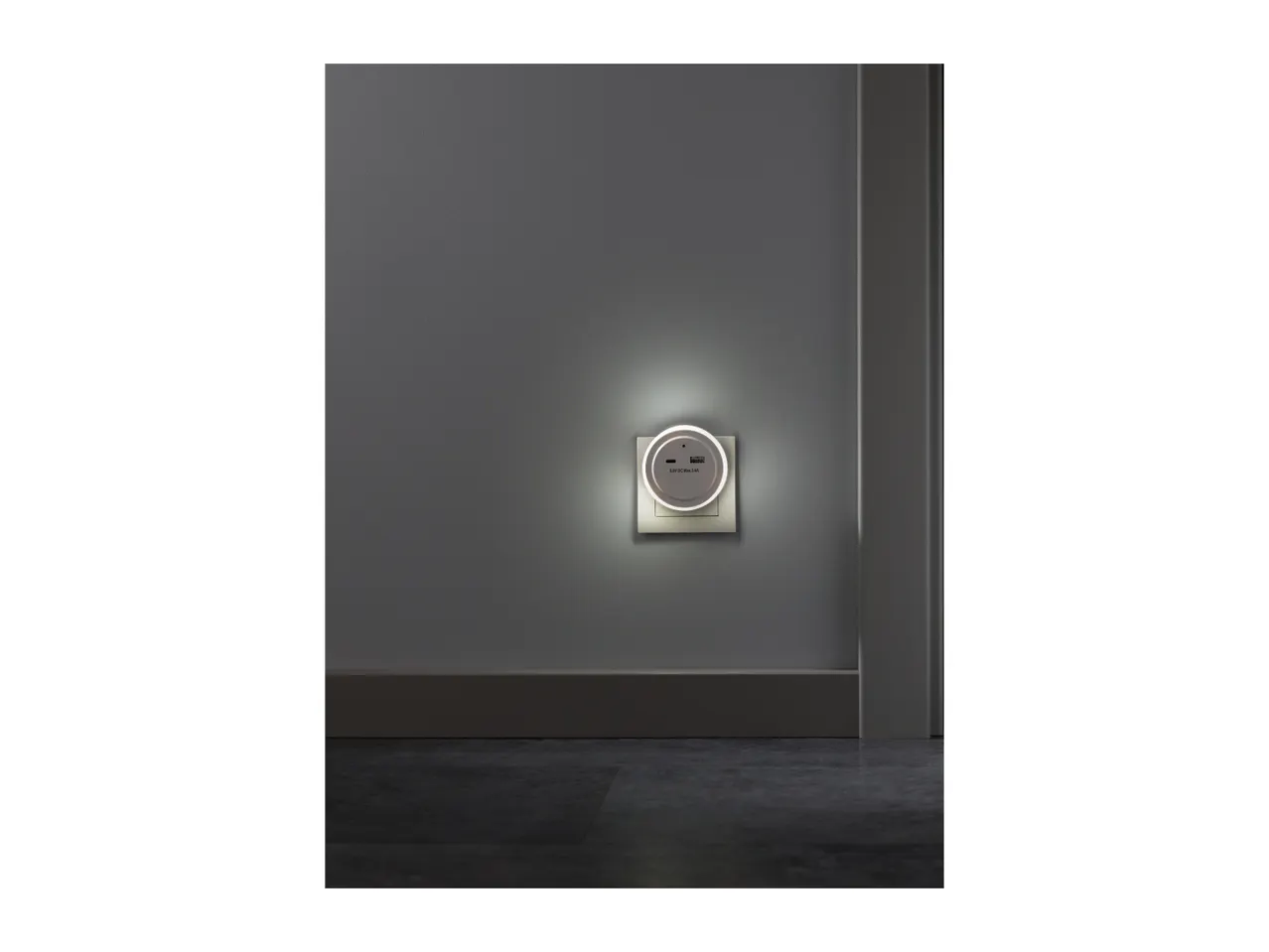 Night light with USB ports plugged into a wall socket, illuminating a dark room.