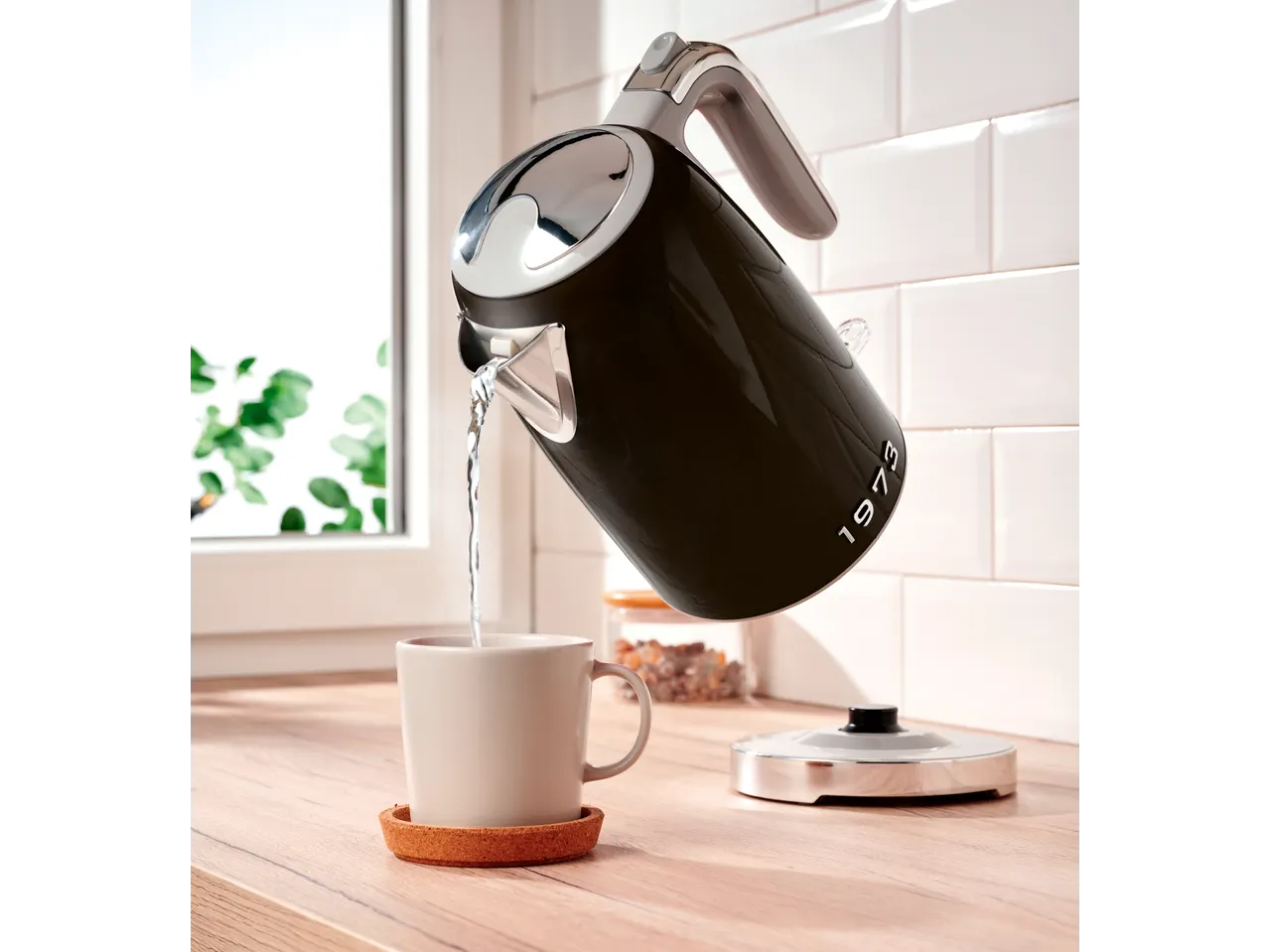 SILVERCREST® Kettle pouring water into a mug on a wooden counter.