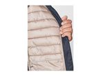 Close-up of a person's hand holding open a navy blue puffer jacket with a light brown lining