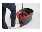 Person using a foot-pedal mop bucket to wring out a mop.