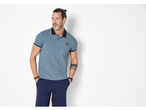Homem com polo azul, calções azul-marinho e pulseiras de madeira.