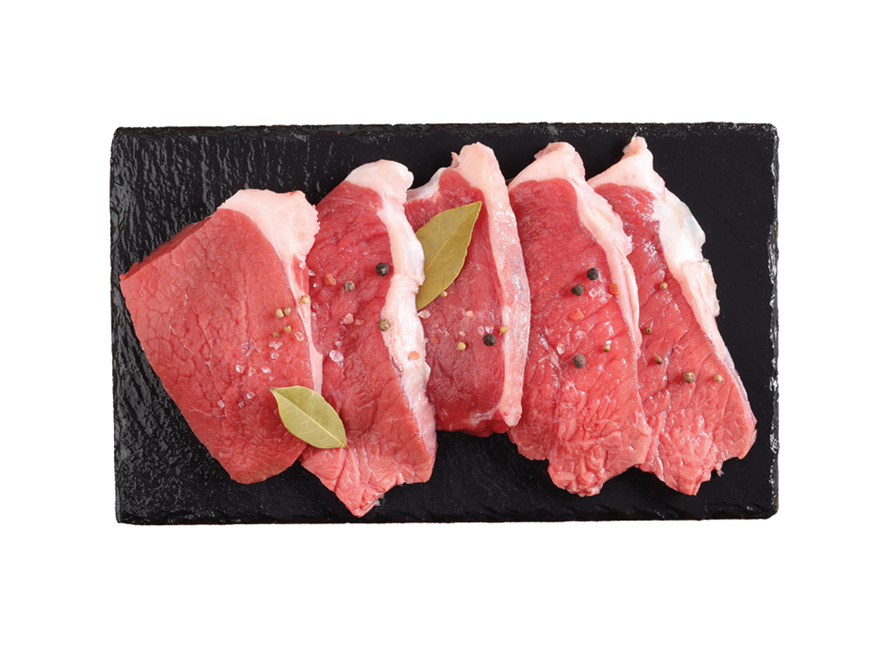 Sveži komadi mesa sa začinima i lovorovim listom na crnoj ploči.