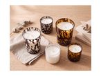 A collection of scented candles in stylish tortoiseshell glass jars on a wooden table.