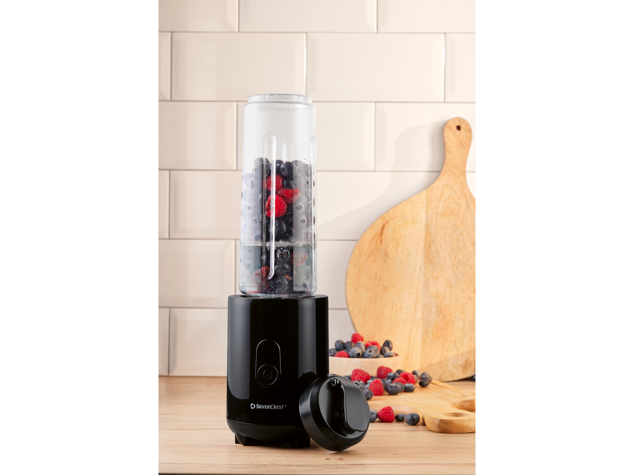 Liquidificador de smoothies SILVERCREST com bagas numa bancada de madeira.