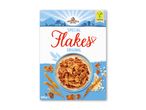 Pakke med morgenmadsprodukt med sprøde flager, serveret i en skål med mælk, omgivet af korn og ris.
