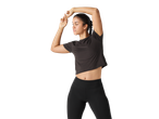 Woman in black sports top and leggings stretching
