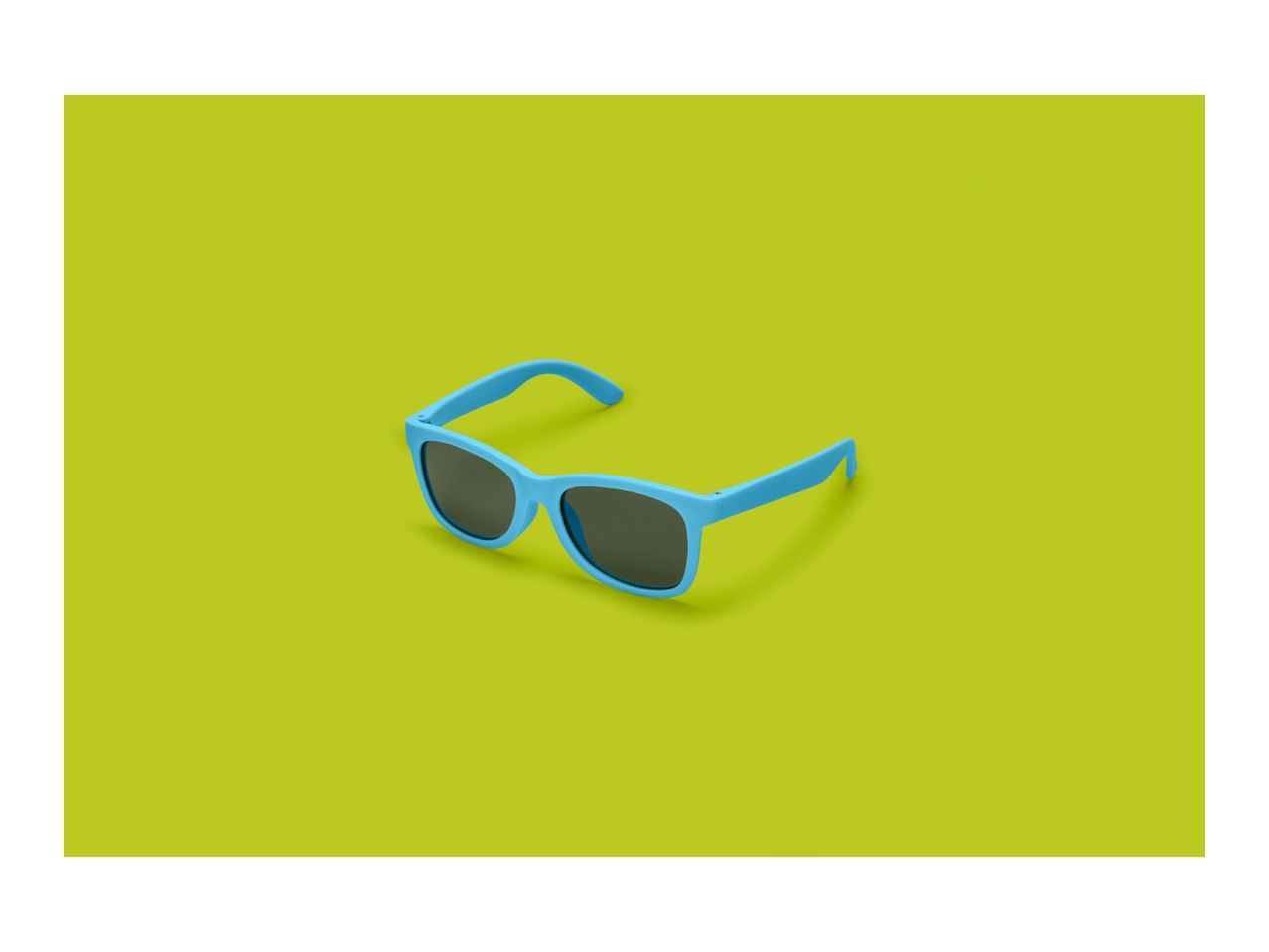 Blue sunglasses with dark lenses on a vibrant lime green background.