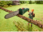 Man uses a PARKSIDE cordless pole saw to prune a branch in a garden.
