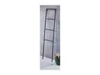 Black metal towel ladder leaning against a gray tiled wall, with a white bath mat and green basket.