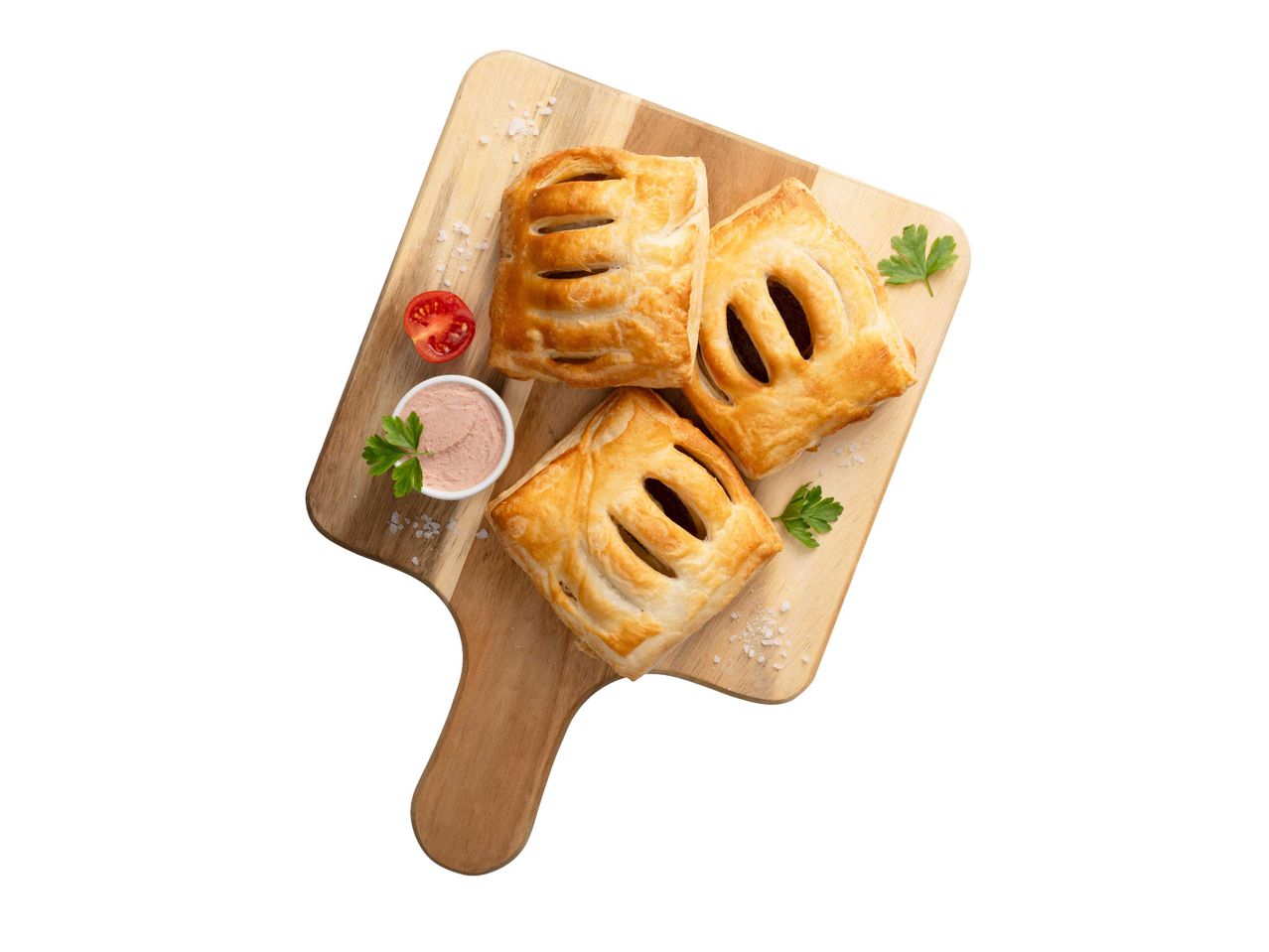 Három leveles tészta sütemény pástétommal, paradicsommal és petrezselyemmel egy vágódeszkán.