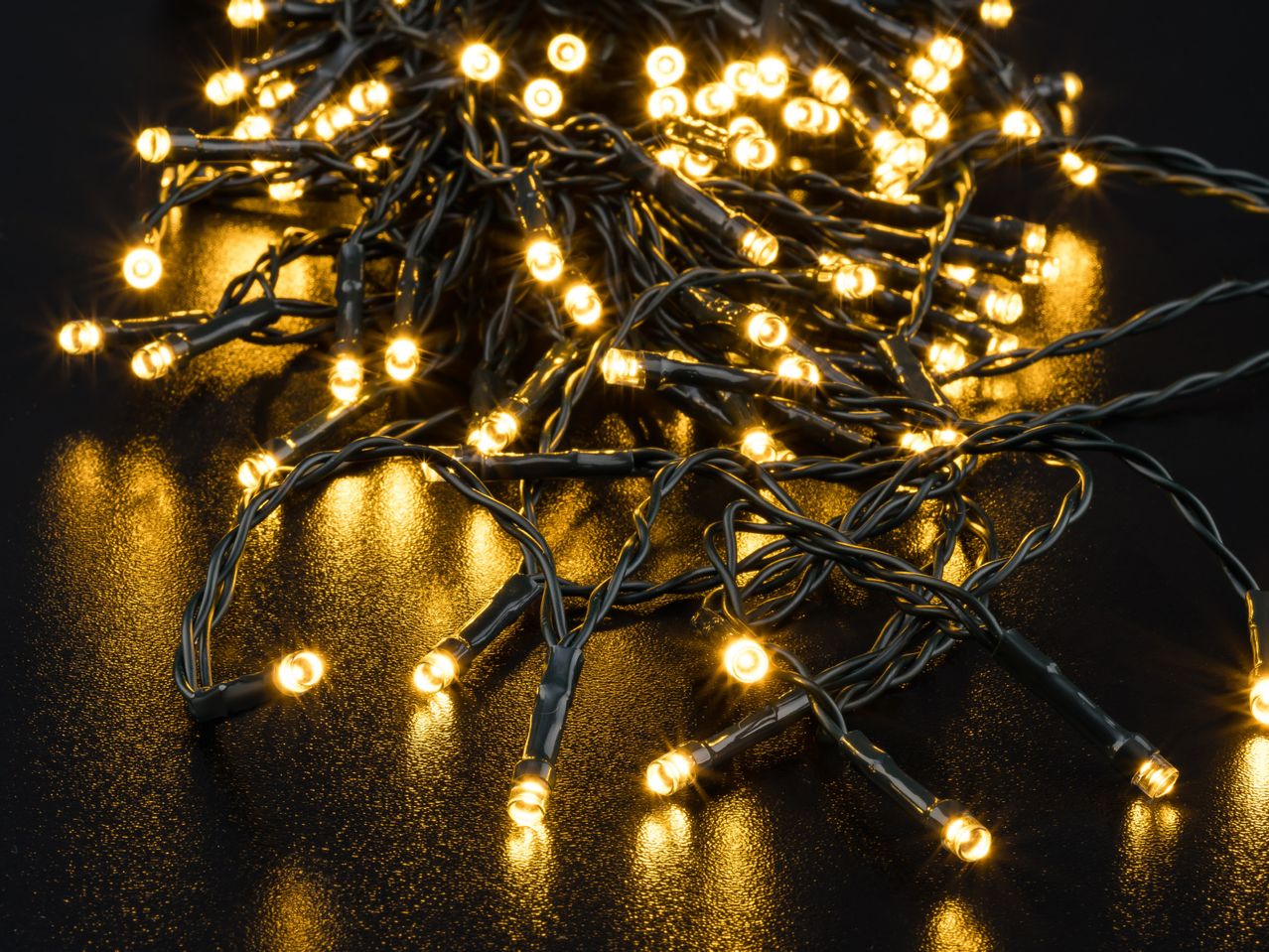 Warm white LED string lights on a dark surface, creating a festive glow.