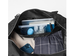 Mala de viagem preta aberta com tablet, caderno, produtos de higiene pessoal, roupas e telefone