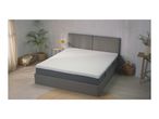 A grey bed with a white mattress in a bedroom setting.