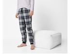 Pantaloni de pijama din flanelă Esmara Men, în carouri, cu manșete elastice, lângă un otoman alb.