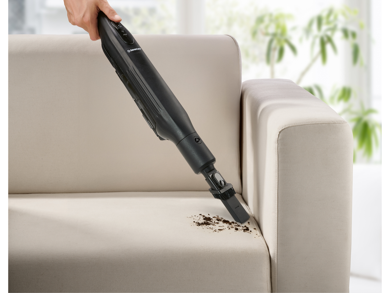 Silvercrest® 2 u 1 bežični usisivač čisti prljavštinu sa sofe.