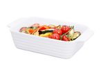 Roasted vegetables including cherry tomatoes, zucchini, bell peppers, and red onion in a white baking dish.