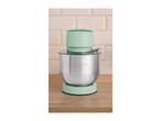 Mint green stand mixer with a stainless steel bowl on a wooden counter.