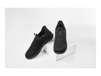 Pair of black slip-on sneakers on a white display stand
