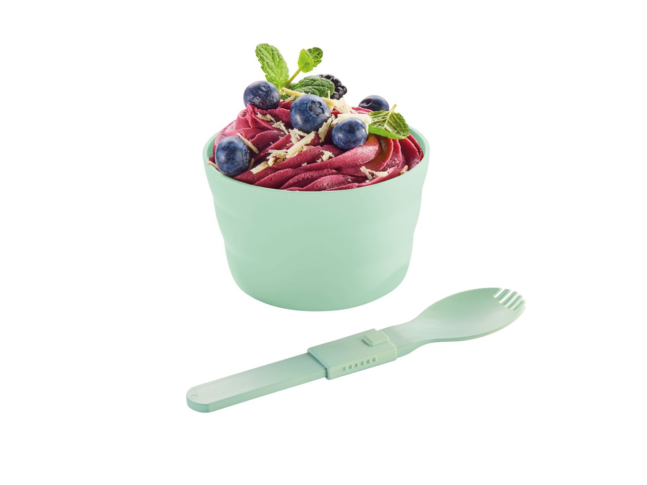 Lilla acai-skål med blåbær, brombær og mynte i en mintgrøn kop med en matchende ske.