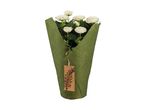 White roses in green burlap wrapping with a brown tag.