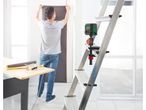 A Parkside laser level is mounted on a ladder, with a person in the background hanging wallpaper.