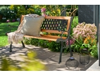 Livarno Garden Bench with a cushion and throw, surrounded by lush garden plants.