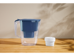Set de filtrare a apei SILVERCREST® cu cană și filtru pe o masă de lemn.