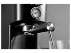 Close-up of a black retro-style espresso machine with a pressure gauge.