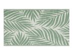 Green and white outdoor rug with a palm leaf pattern.