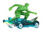 En grøn legetøjssurferfigur på en blå legetøjsbil med et surfbræt.