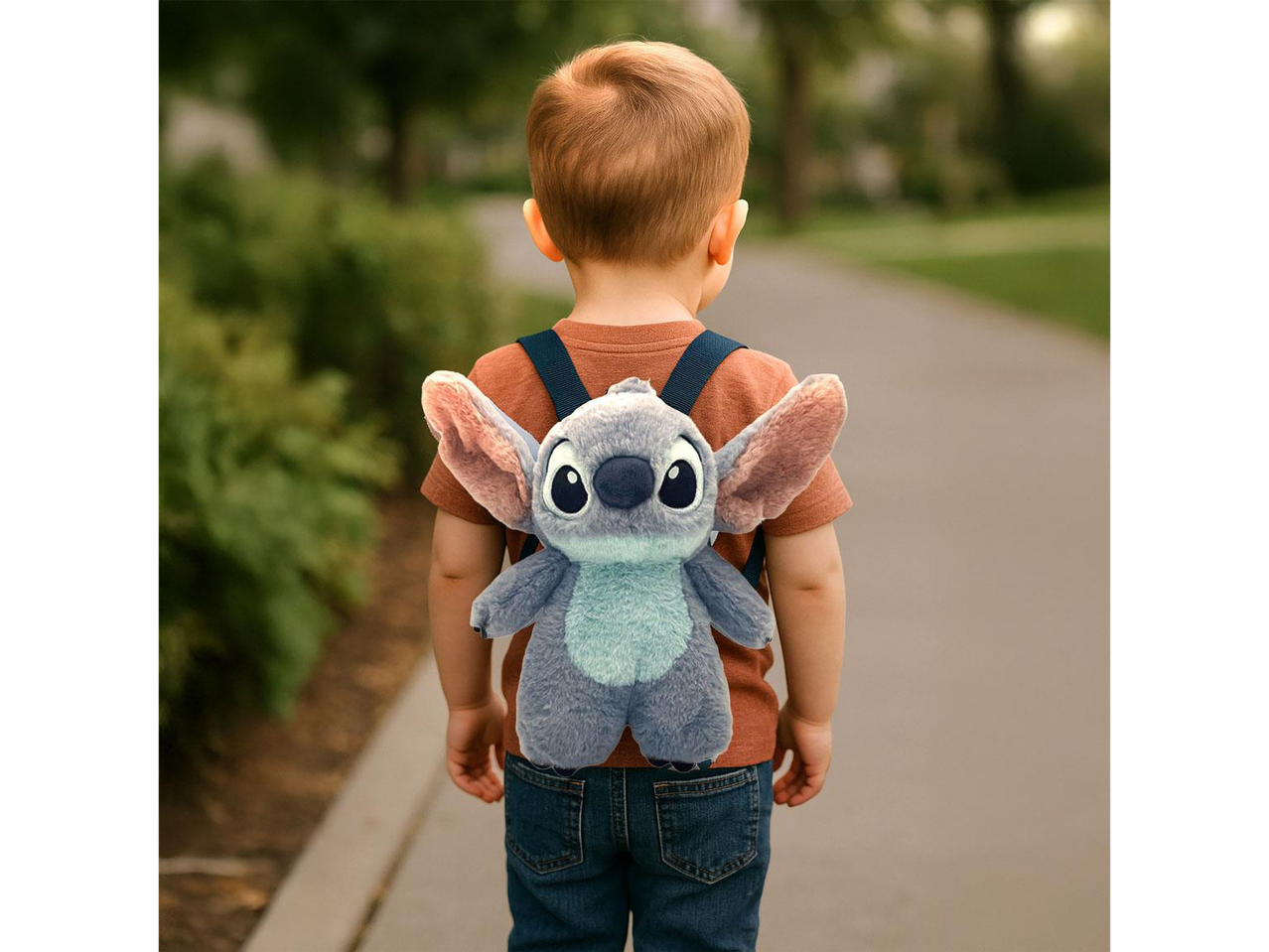 A child wearing a Stitch plush backpack walks away on a path.