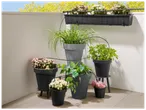 Balcon avec jardinières et pots de fleurs, équipés d'un système d'arrosage goutte-à-goutte.