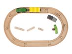 Wooden toy train set with a green and yellow train on an oval track, with loose blocks and a tree.