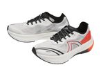 Two white and black athletic shoes with orange accents, one slightly behind the other.