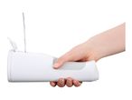 Hand holding a white oral irrigator while water is being poured into its reservoir.