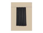 Black waffle-textured shower curtain hanging on a silver rod against a beige wall.