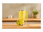 Yellow insulated tumbler with a handle and straw, with its lid beside it, on a wooden counter.