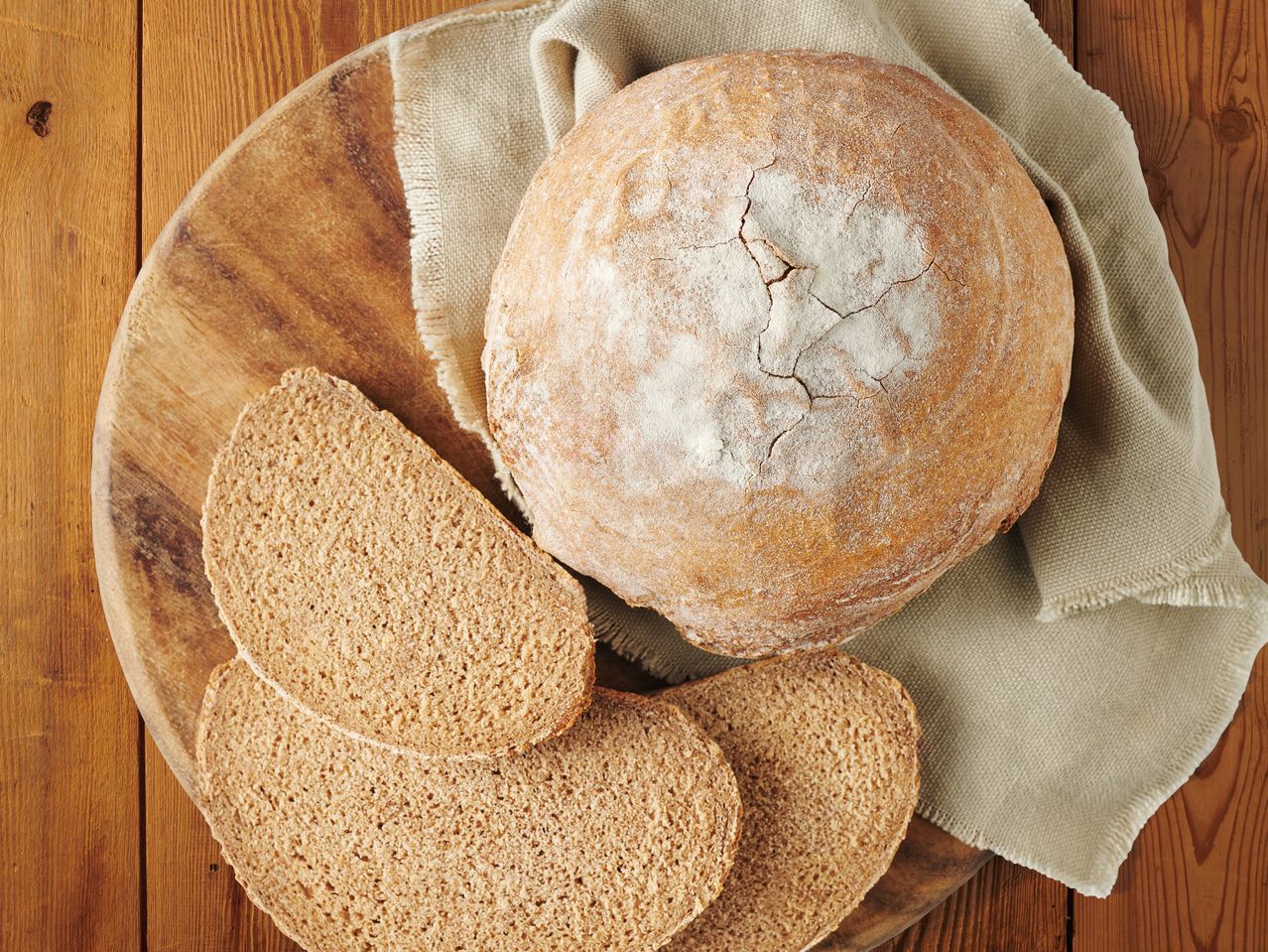 Хляб от ръжен хляб и филийки от пълнозърнест хляб върху дървена дъска.