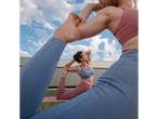 Two women in CRIVIT sports bras and leggings doing yoga outdoors.