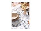Table set with blue leaf-patterned tablecloth, beige plates, glasses, and a vase with flowers.