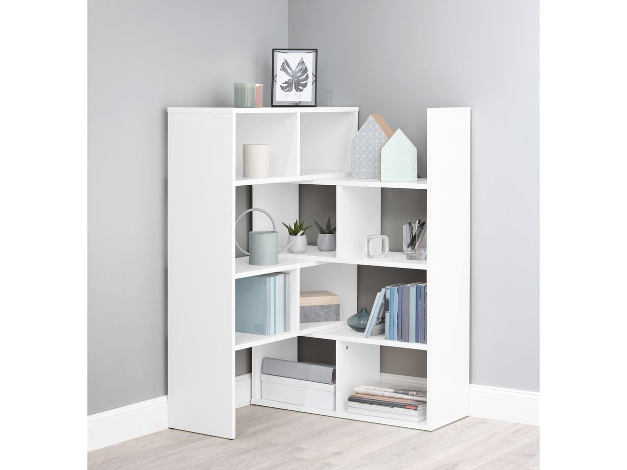 White corner shelving unit with various decorative items and books