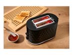 A black two-slice toaster with glowing heating elements next to toast and jam on a wooden table.