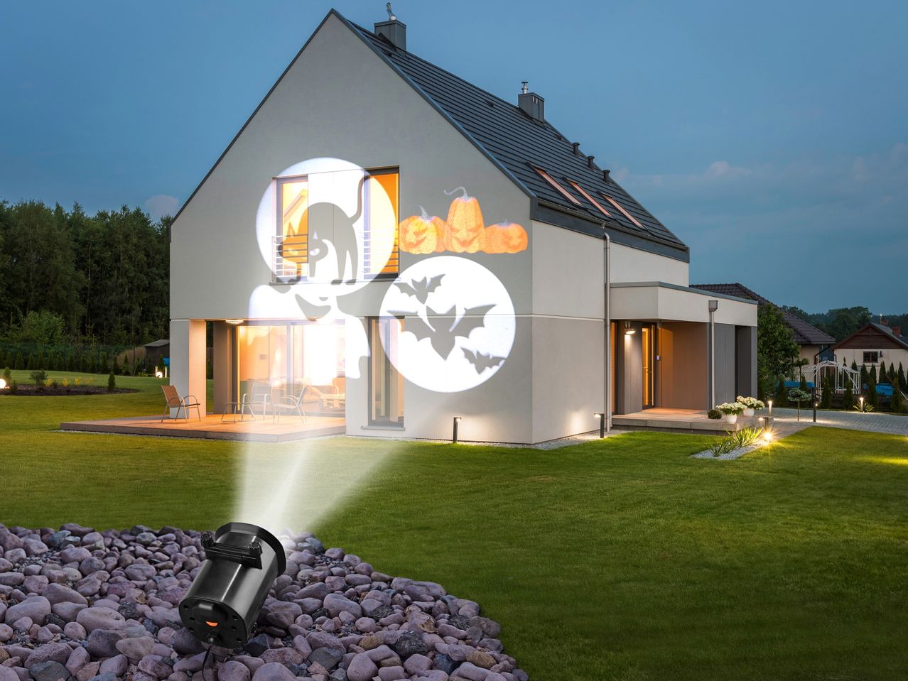 House with Halloween projector displaying cats, pumpkins, and bats on its facade.