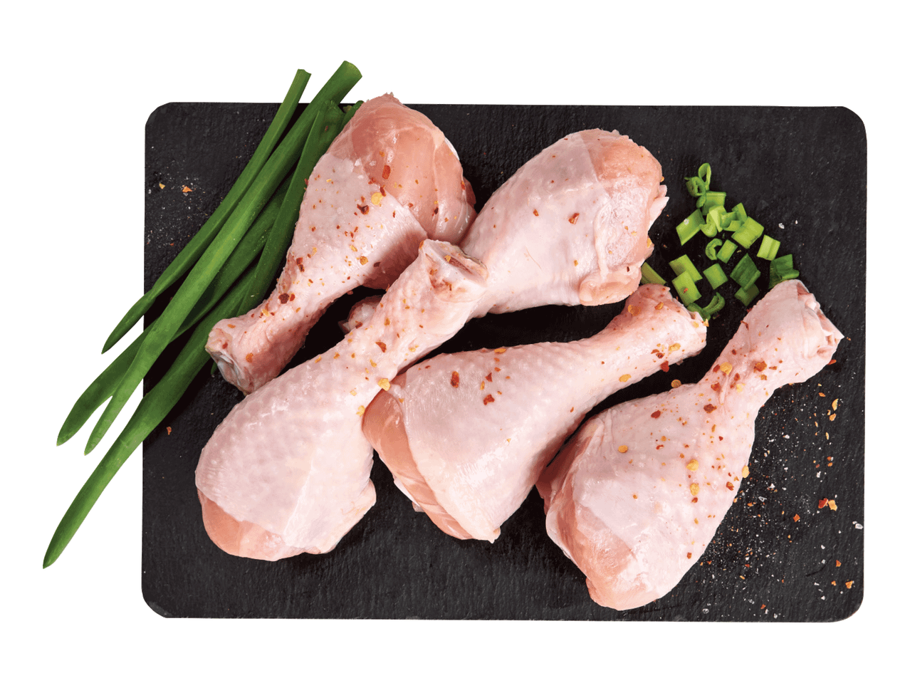 Toored kanakoivad rohelise sibula ja vürtsidega mustal laual.