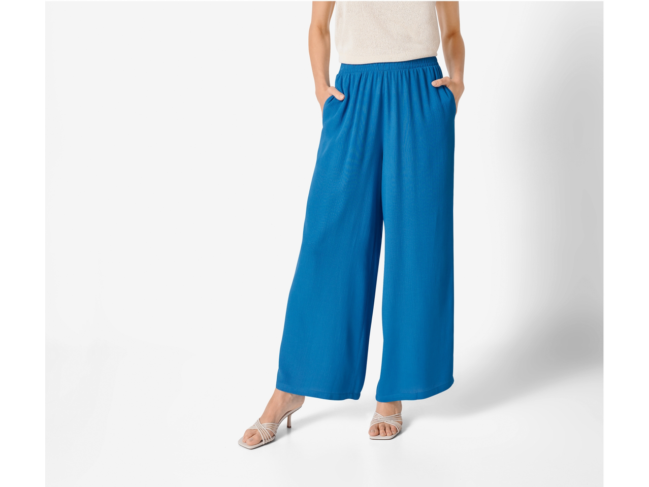 Μπλε φαρδιά παντελόνια και λευκά σανδάλια.