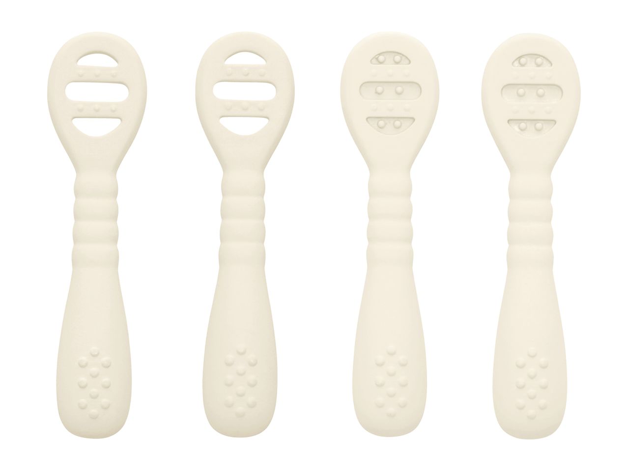 Four cream-colored baby teethers with textured surfaces and handles, two with open slots and two with raised bumps.